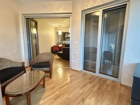 Bright living room with wooden flooring and wicker furniture. - image 16
