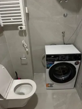 Moderno opremljeno kupatilo sa veš mašinom i WC šoljom. - image 8