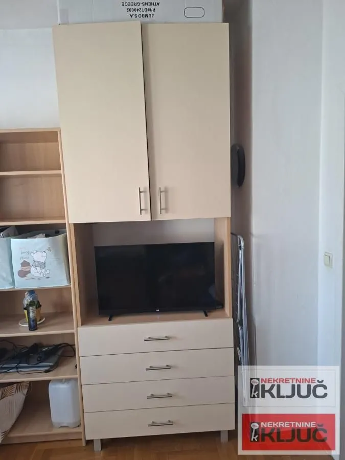 Komad nameštaja sa policama i televizorom.