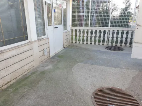 A spacious terrace with a concrete floor and a protective fence. - image 5