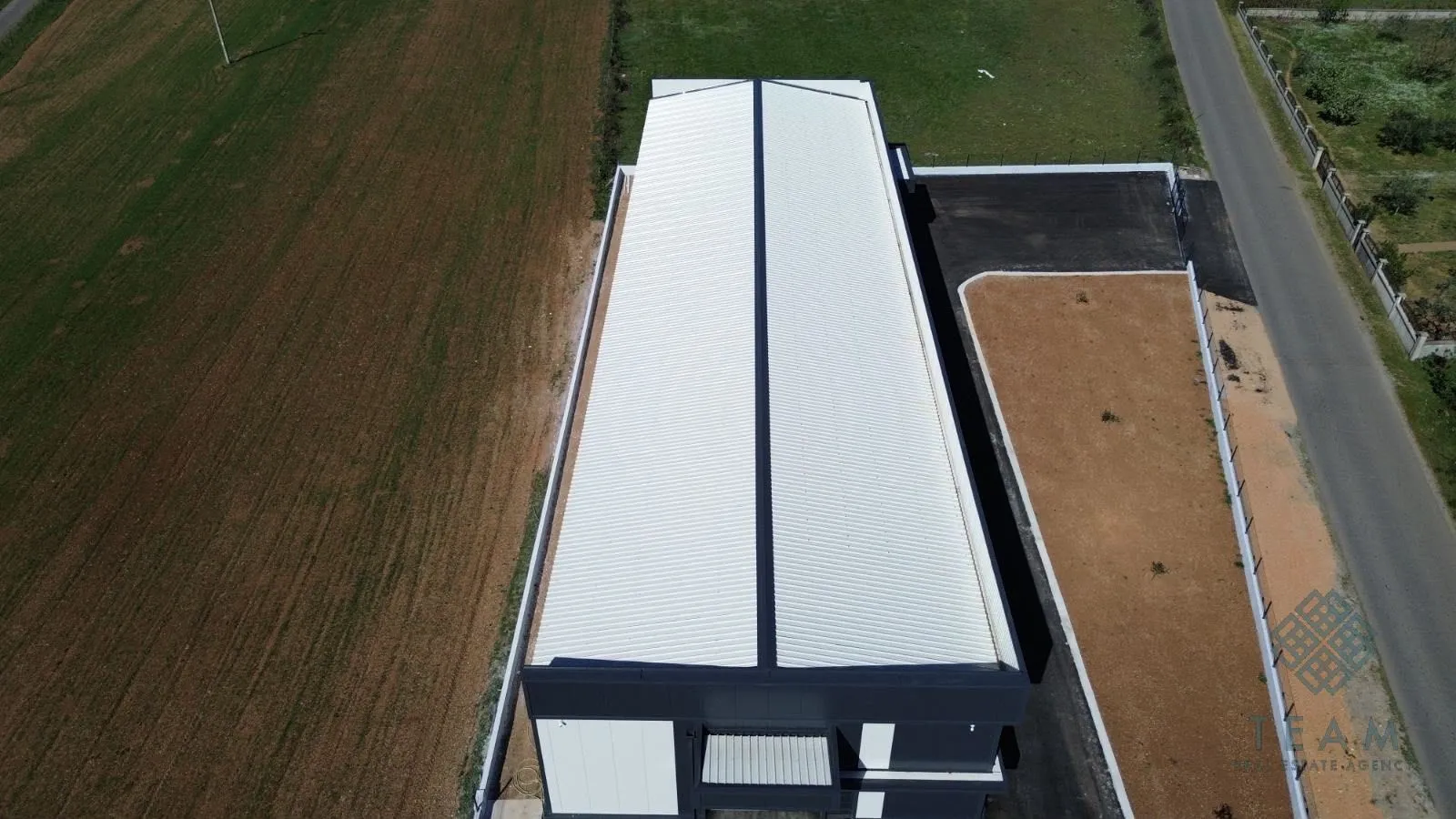 Aerial view of the building with yard and access road.