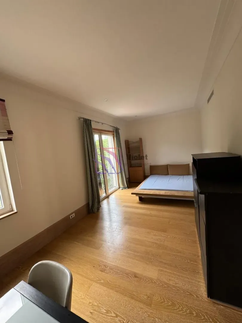 Spacious bedroom with wooden flooring and access to the terrace.