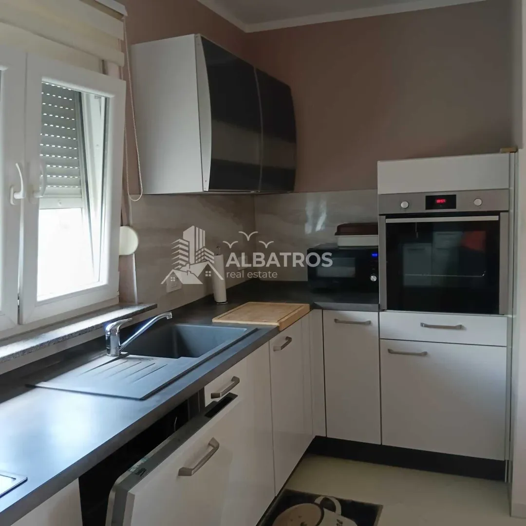 Small kitchen with white cabinets, a sink, and a built-in oven.