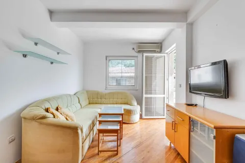 Living room with a corner sofa, coffee table, TV cabinet, and access to the terrace. - image 4