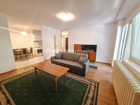 Dnevna soba sa garniturom, stočićem i pogledom na trpezariju sa kuhinjom. - image 4