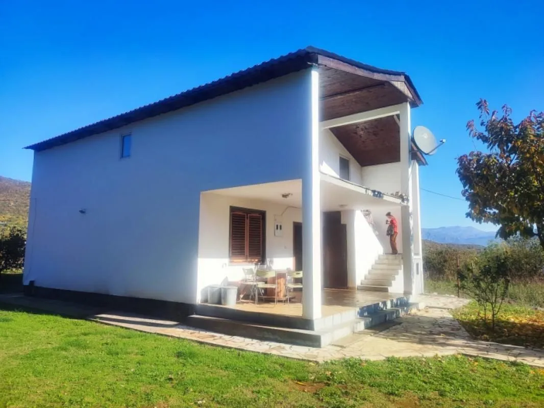 Spoljašnji pogled na kuću sa dvorištem i terasom.