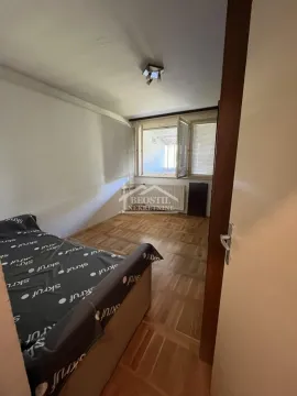 Smaller bedroom with a bed and wooden parquet flooring. - image 4