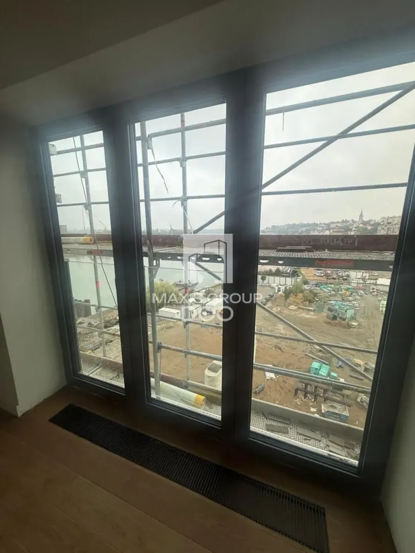 View through large windows overlooking a construction site and surroundings.