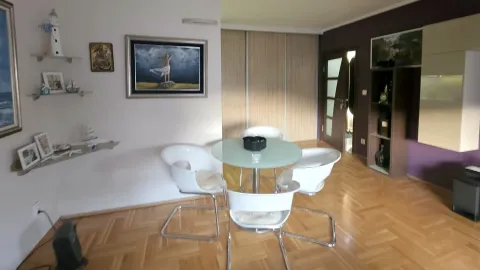 Trpezarija sa okruglim stolom i bijelim stolicama u okviru dnevnog boravka. - image 12