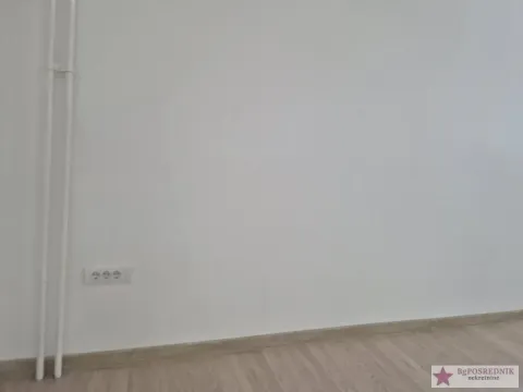 Empty wall with laminate flooring and electrical outlet. - image 7