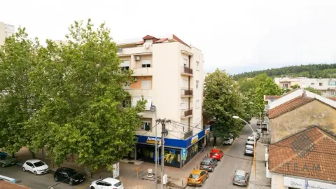 View of a residential building with surrounding streets and greenery. - image 13