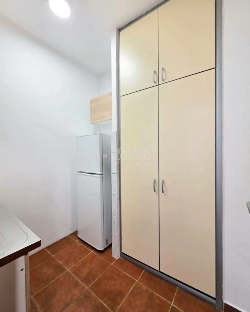Small kitchen with built-in cabinetry and refrigerator.