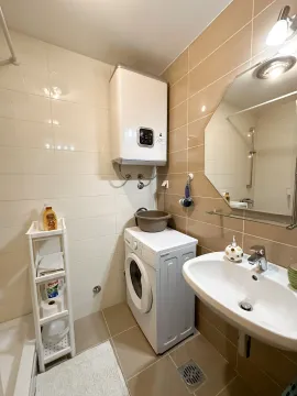 Small bathroom with a sink, washing machine, and water heater. - image 5
