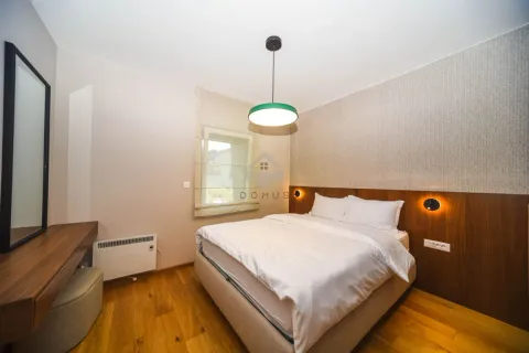 Modern bedroom with a double bed, wooden flooring, and a desk with a mirror. - image 8