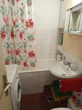 Small bathroom with bathtub, sink, and washing machine. - image 5