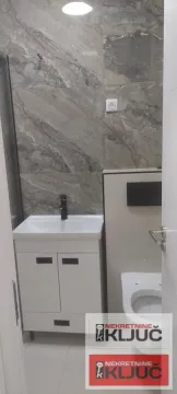 Pogled na moderno opremljeno kupatilo sa umivaonikom i toaletom. - image 12