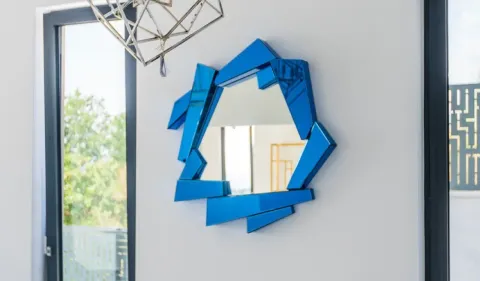 Detalj enterijera sa modernim plavim ogledalom na zidu. - image 10