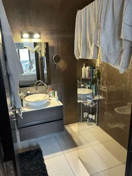 Moderno kupatilo sa tamnim pločicama, lavaboom i staklenom tuš kabinom. - image 8