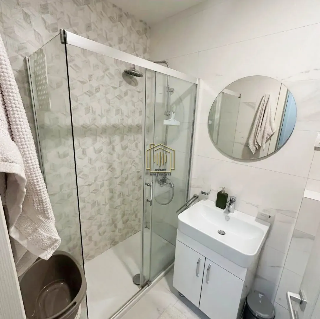 Modern bathroom with a walk-in shower and a vanity unit.