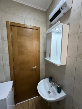 Manje kupatilo sa umivaonikom, ogledalom i drvenim vratima. - image 8