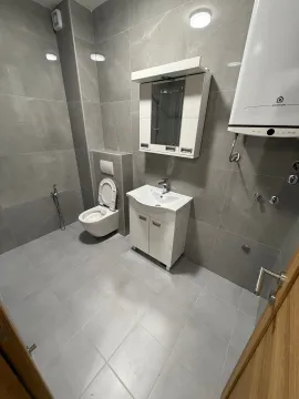 Moderne opremljeno kupatilo sa sivim pločicama i bijelim sanitarijama. - image 9