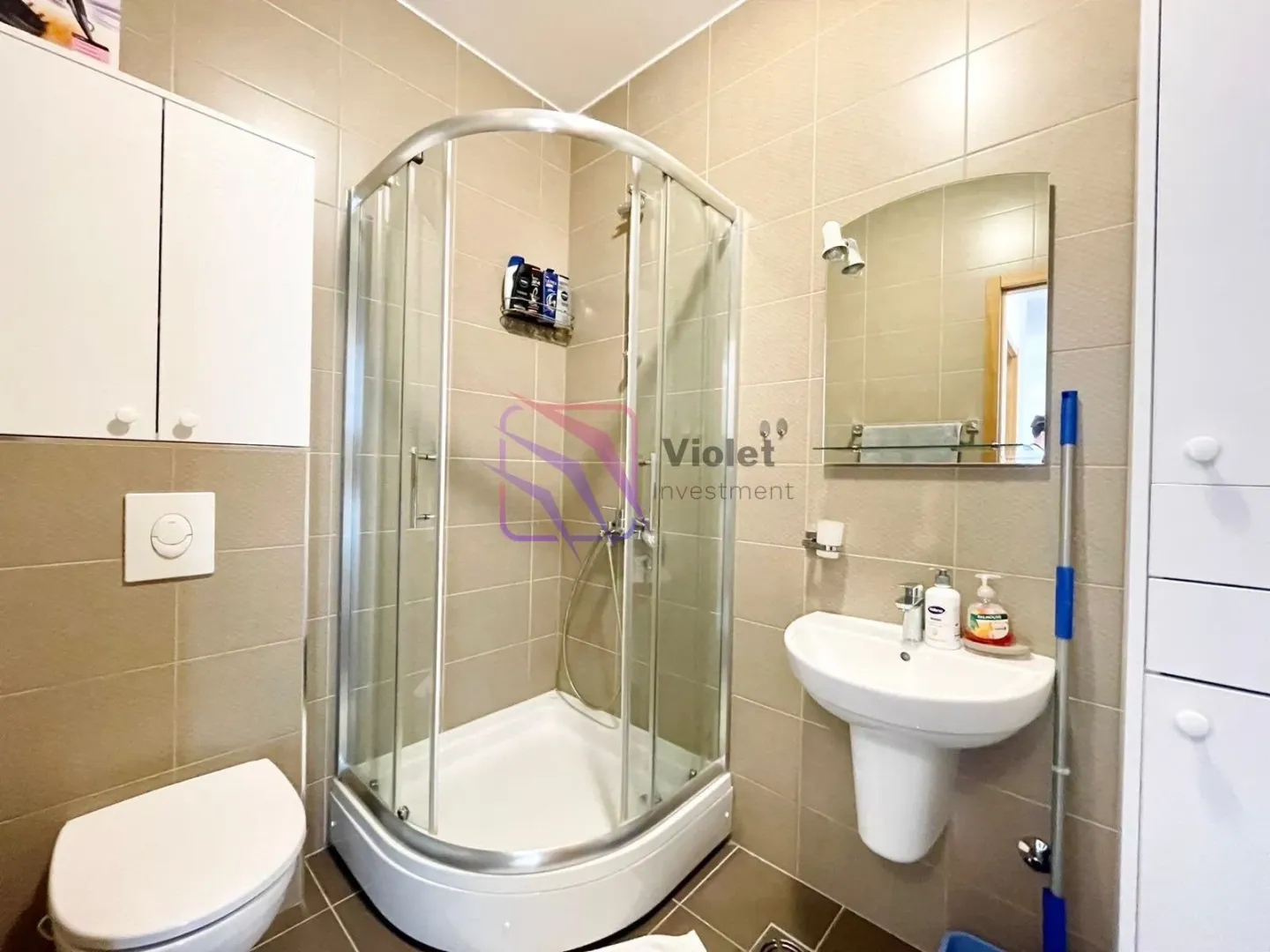 Bathroom equipped with a shower cabin, washbasin, and toilet.