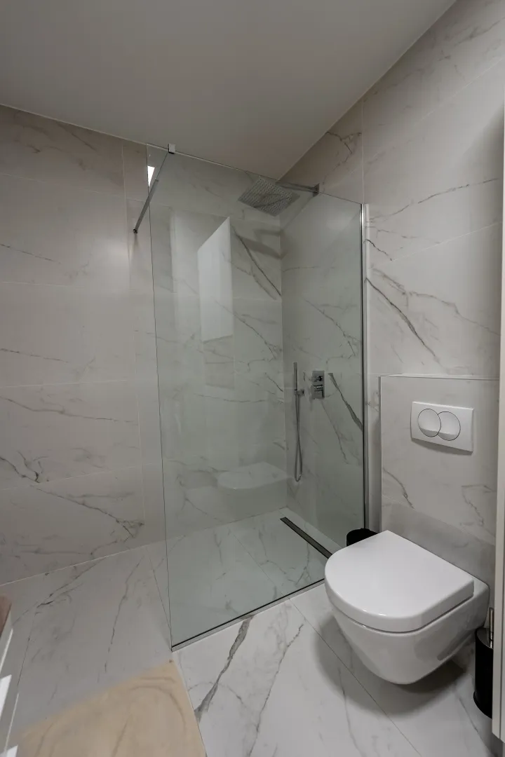 Moderne kupatilo sa tuš kabinom i ugradnim sanitarijama.