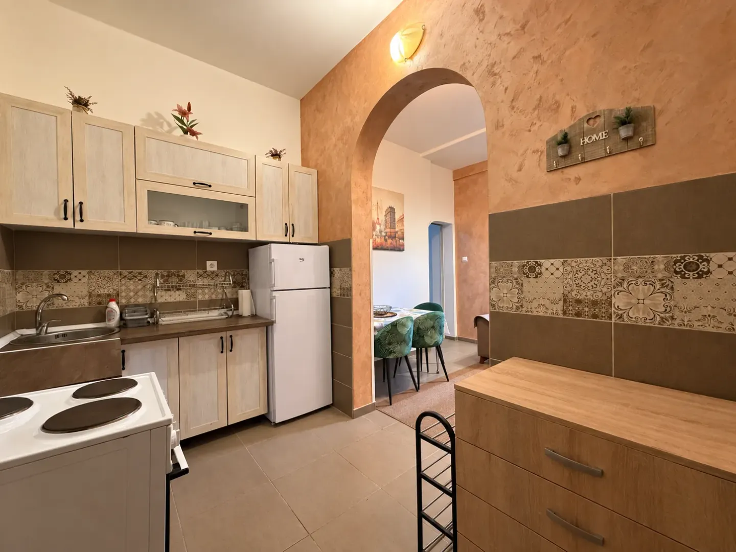 Small kitchen with light wood cabinetry and a white refrigerator.