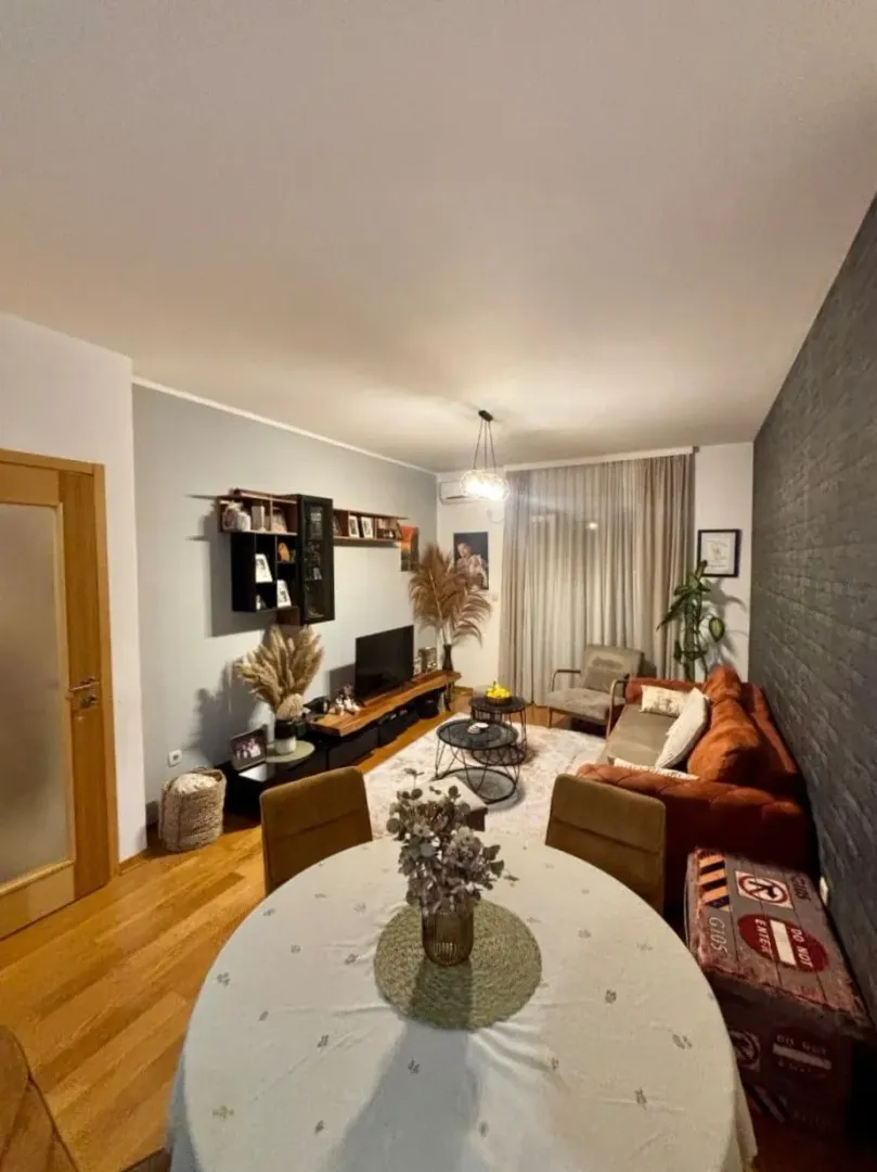 Living room with a dining area, sofa set, and TV unit.