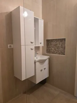 Savremeno opremljeno kupatilo sa bijelim elementima i umivaonikom. - image 16