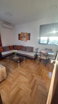 Living room with a sectional sofa, coffee table, and dining area. - image 3