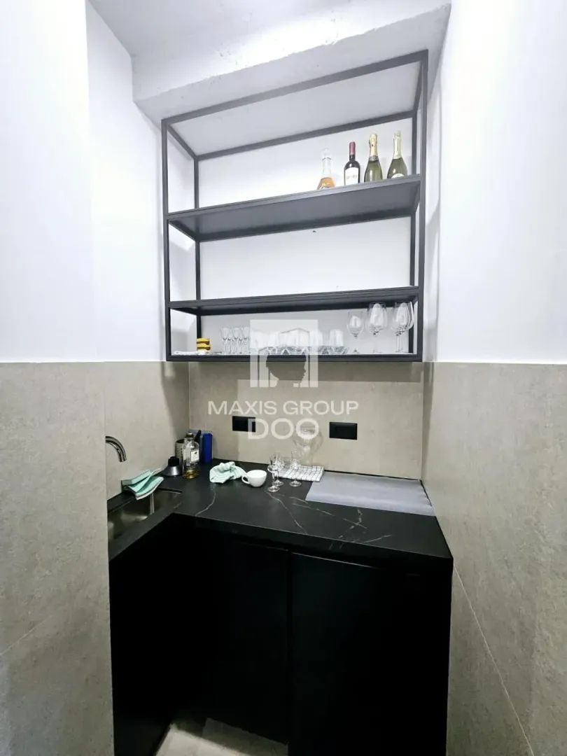 Small kitchen with black cabinets and open wall shelving.