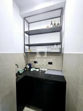 Small kitchen with black cabinets and open wall shelving. - image 2