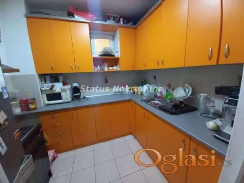 Kuhinja sa narandžastim elementima i sivom radnom površinom. - image 4