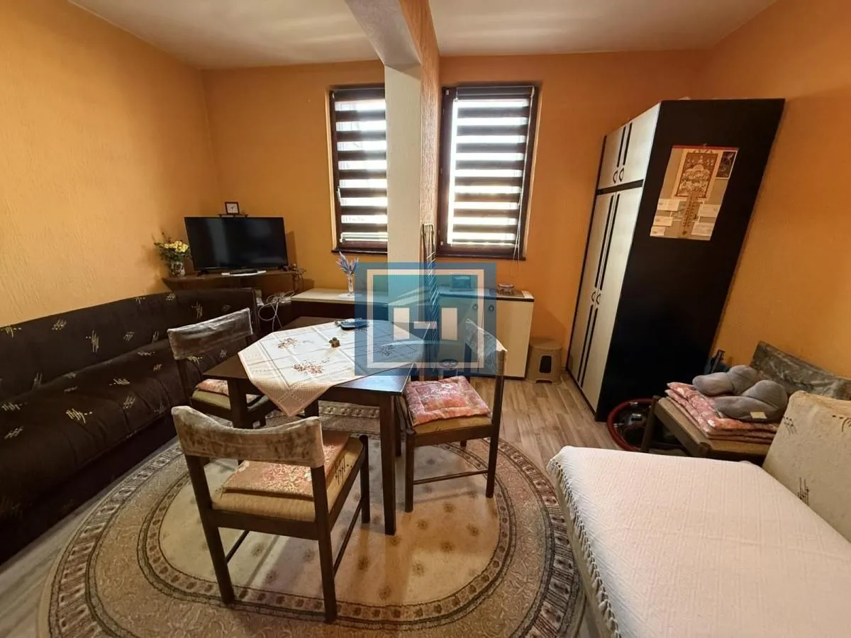 Living room with sofa, dining table and wardrobe.