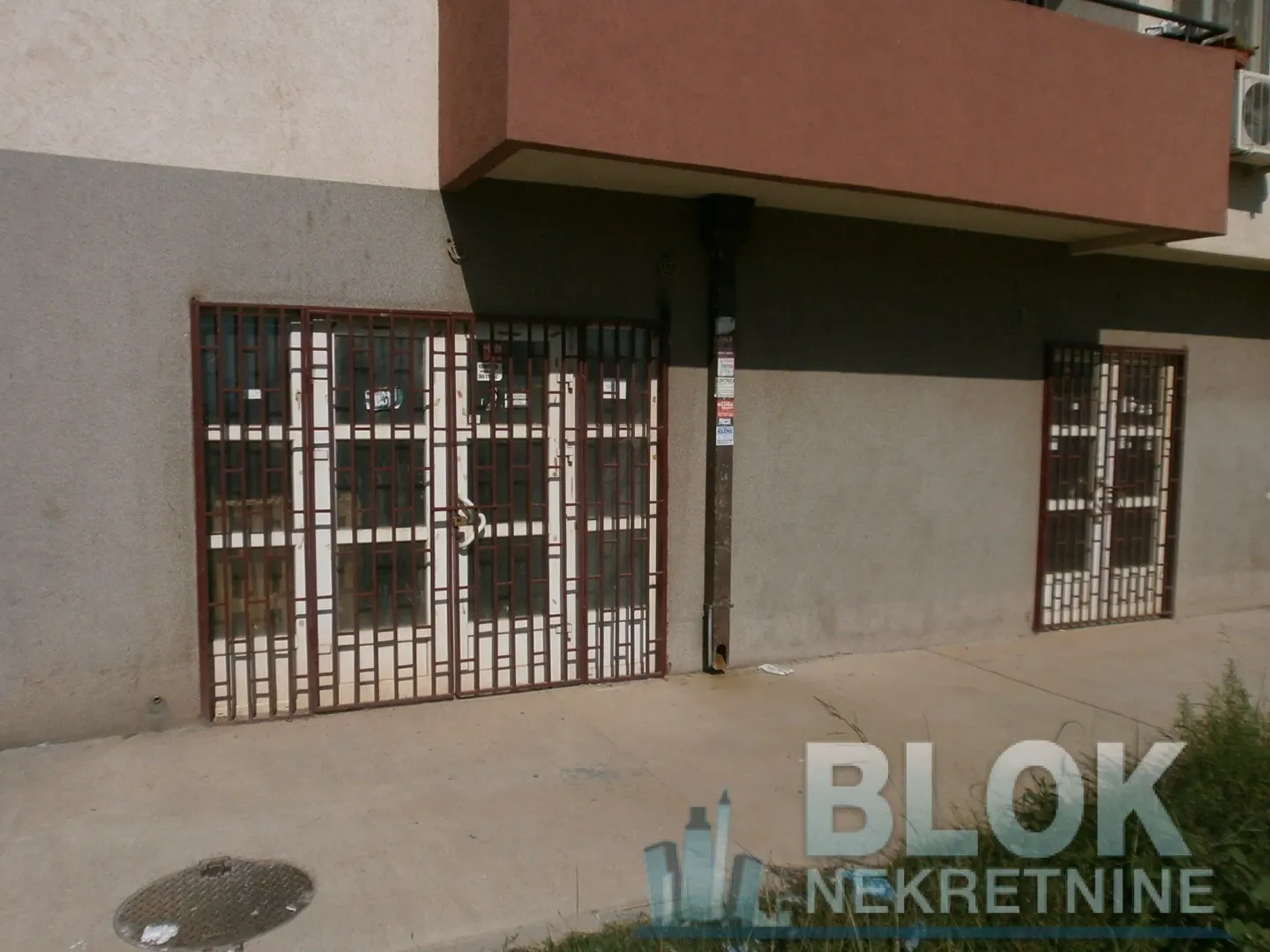 View of the commercial space entrance with security grills.