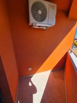 Manji popločani balkon sa spoljnom jedinicom klima uređaja na narandžastom zidu. - image 8