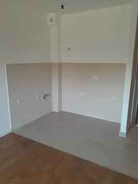 An empty corner of a room with floor and wall tiles and utility connections. - image 2