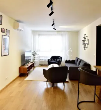 Furnished living room with sofa set, TV, and wooden flooring. - image 2