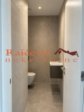 Pogled na moderno opremljeno kupatilo sa sanitarijama i pločicama u sivoj boji. - image 7