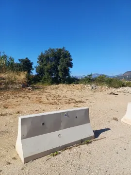 Pogled na plac sa rastinjem i betonskom preprekom u prvom planu. - image 8