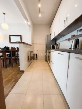 View of the kitchen with white cabinetry and a view of the dining area. - image 7