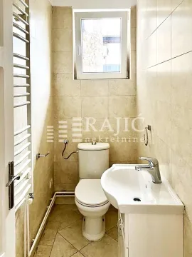 Smaller bathroom with a toilet, washbasin, and radiator. - image 7