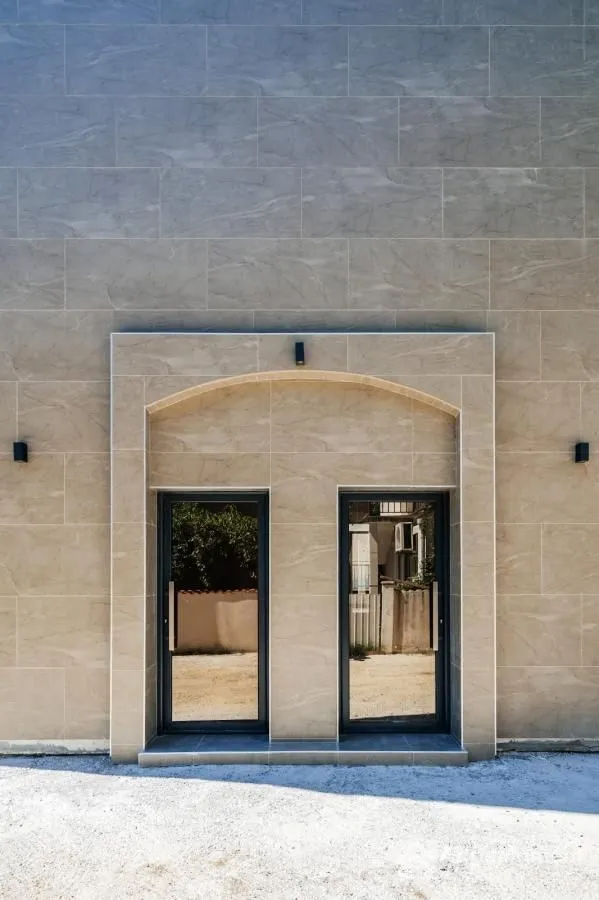Main entrance of the building with a tiled facade and glass doors.