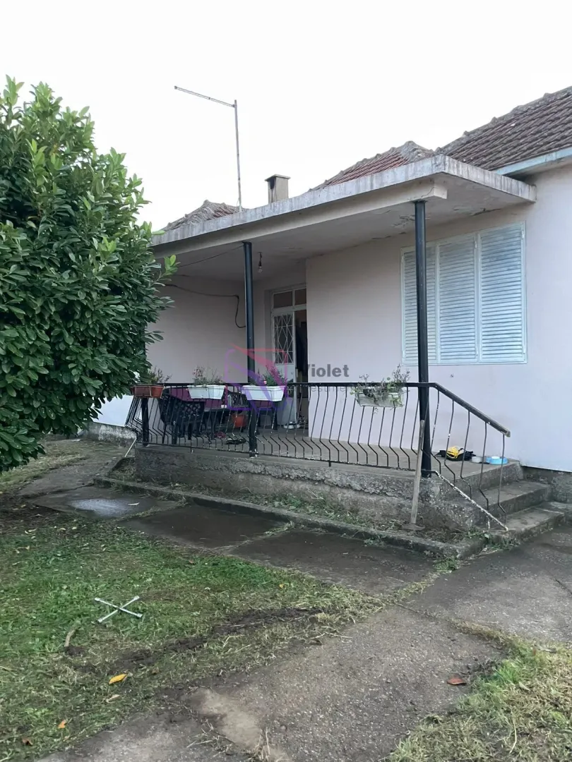 Pogled na ulaz i natkrivenu terasu kuće sa dvorištem.