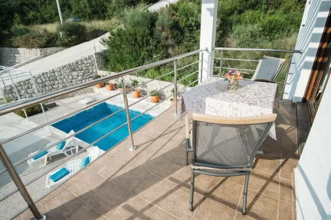 Terrace with a table, chairs, and a view of the pool. - image 2