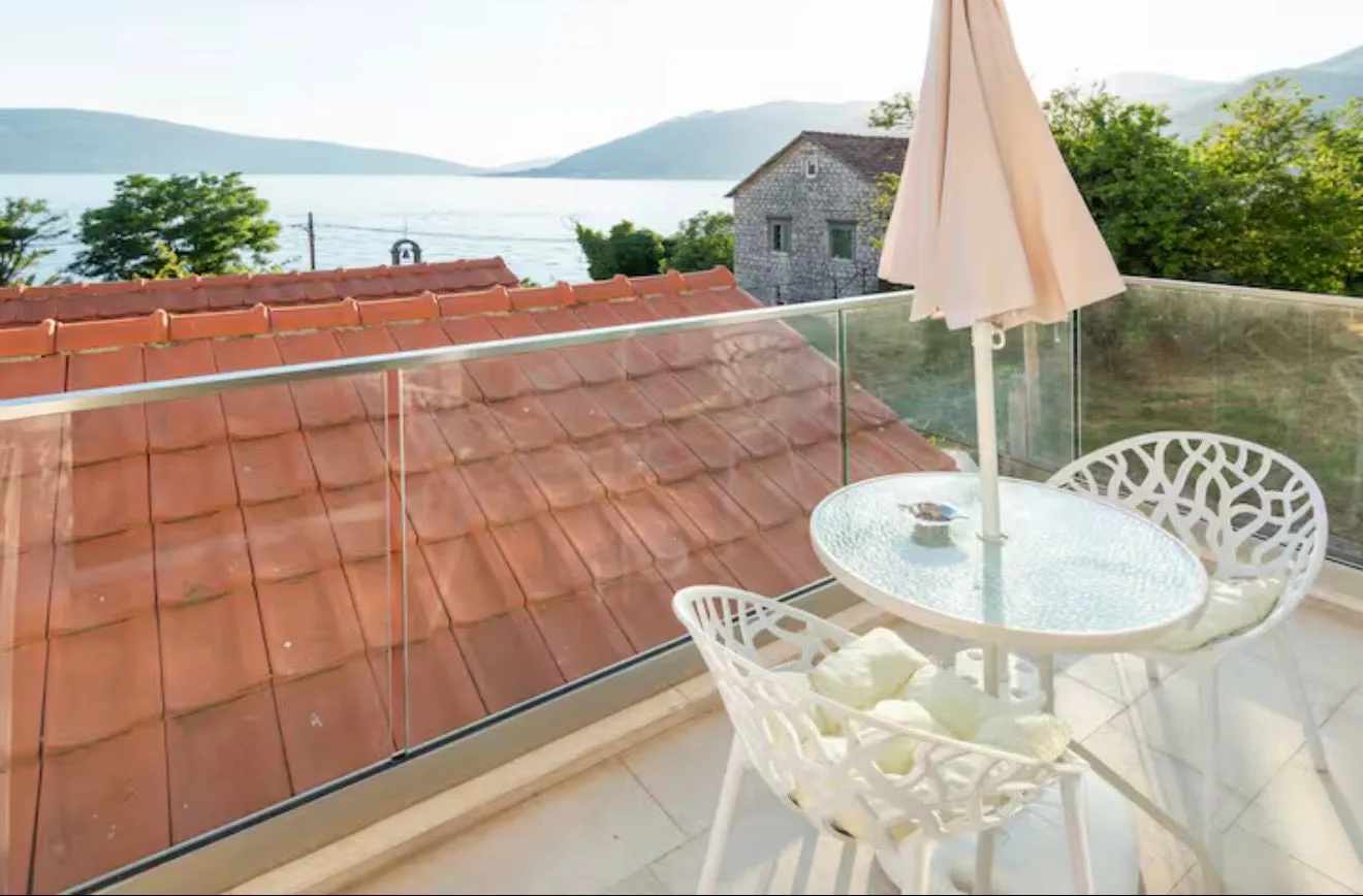 Furnished terrace with a table, chairs, parasol and sea view.