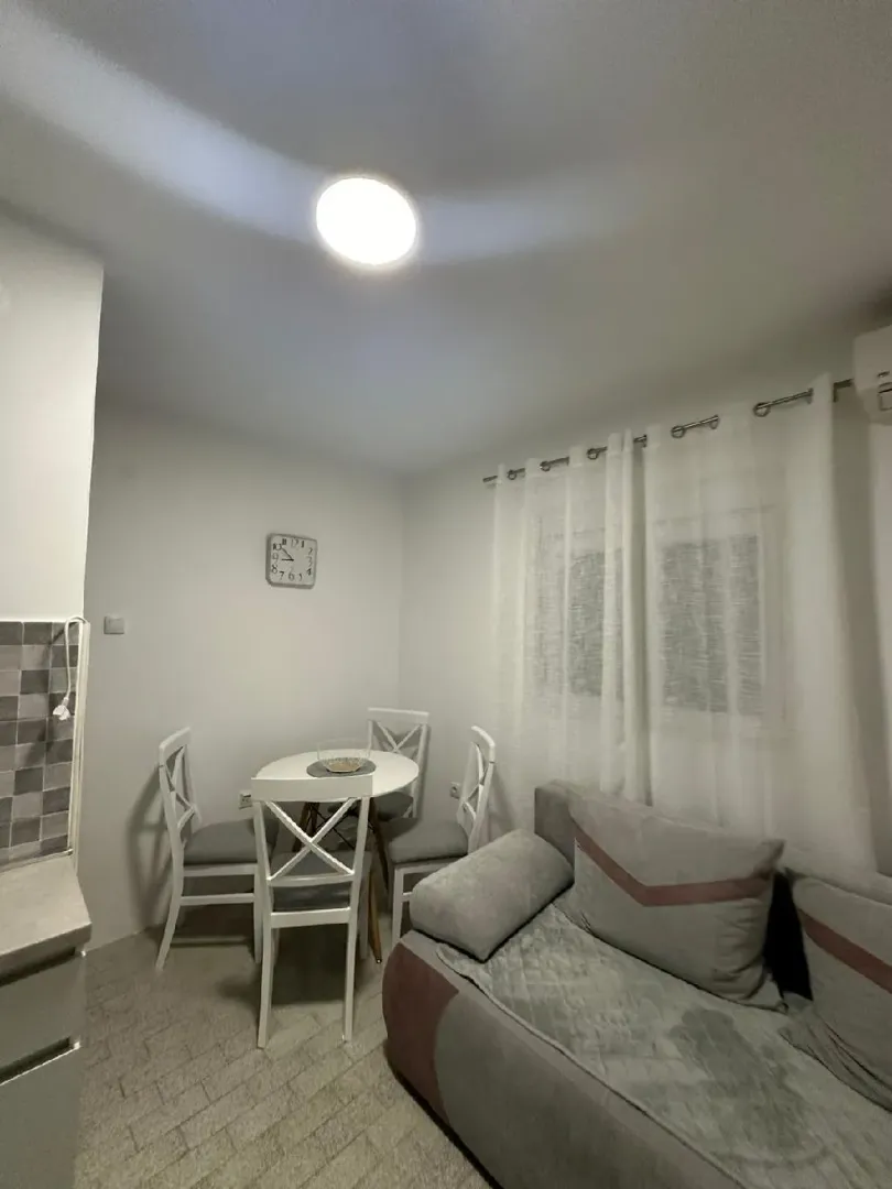 Small living room with a sofa and a dining table.