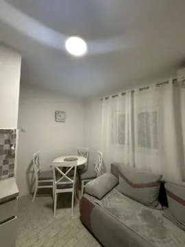 Small living room with a sofa and a dining table. - image 4