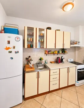 Manja kuhinja sa bijelim frižiderom, sudoperom i šporetom. - image 3